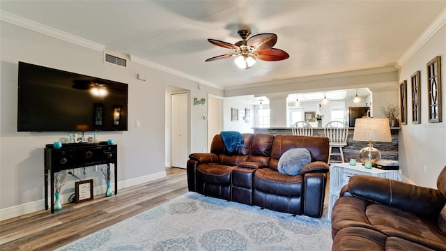 living room featuring ceiling fan, crown molding, and hardwood / wood-style flooring