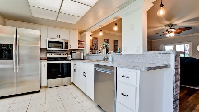 kitchen with crown molding, appliances with stainless steel finishes, ceiling fan, white cabinets, and kitchen peninsula