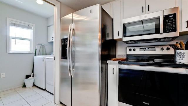 kitchen featuring light tile patterned flooring, stainless steel appliances, independent washer and dryer, and white cabinetry