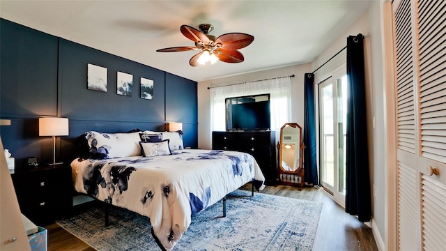 bedroom featuring ceiling fan, light wood-type flooring, and multiple windows