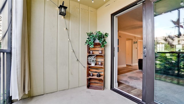 exterior space with light hardwood / wood-style flooring and crown molding