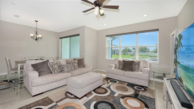 living room with ceiling fan with notable chandelier