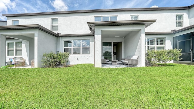 rear view of property with a lawn and a patio