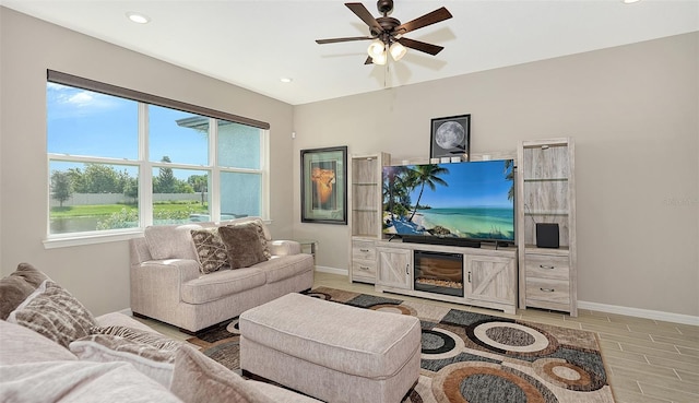 living room with light hardwood / wood-style flooring and ceiling fan