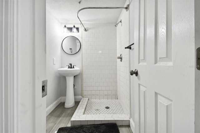 bathroom featuring a tile shower and hardwood / wood-style flooring