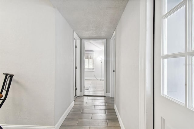 hall featuring a textured ceiling and hardwood / wood-style floors