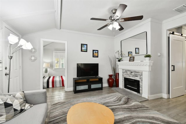 living room with vaulted ceiling with beams, light hardwood / wood-style flooring, ornamental molding, and ceiling fan