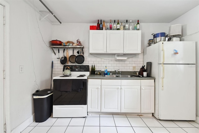 kitchen with white appliances, light tile patterned floors, decorative backsplash, sink, and white cabinetry