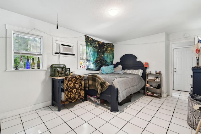 bedroom with an AC wall unit and light tile patterned flooring