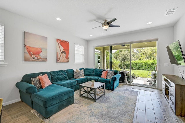 living room with plenty of natural light, ceiling fan, and wood-type flooring