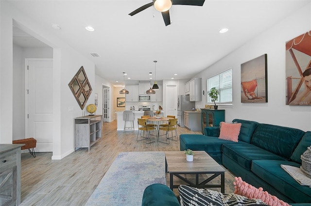 living room featuring ceiling fan and light wood-type flooring