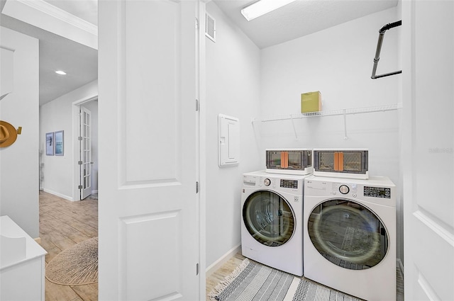 laundry area with washer and clothes dryer and light hardwood / wood-style floors