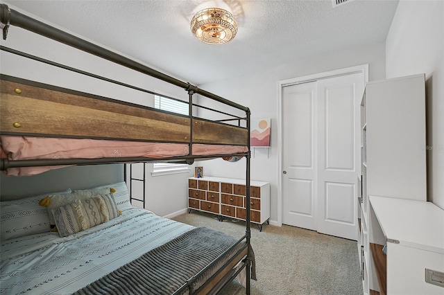 bedroom featuring a textured ceiling, carpet floors, and a closet