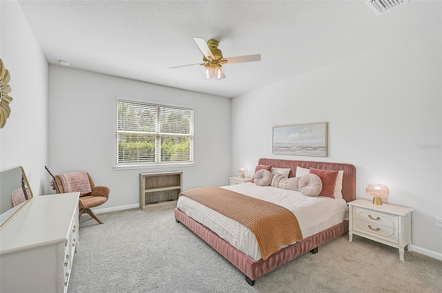 carpeted bedroom featuring a textured ceiling and ceiling fan