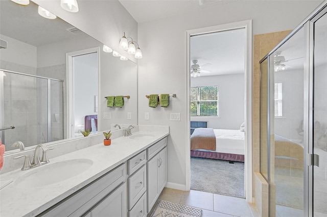 bathroom with tile patterned floors, ceiling fan, a shower with door, and vanity