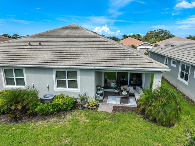 back of property with central AC unit, a patio area, an outdoor hangout area, and a yard