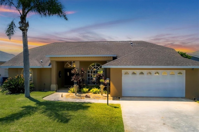 ranch-style house with a yard and a garage