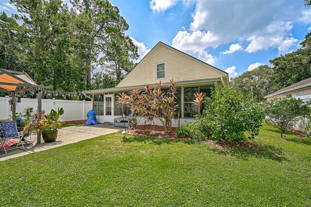 back of property with a yard and a patio