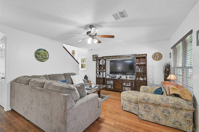 living room featuring a wealth of natural light, a textured ceiling, and hardwood / wood-style flooring