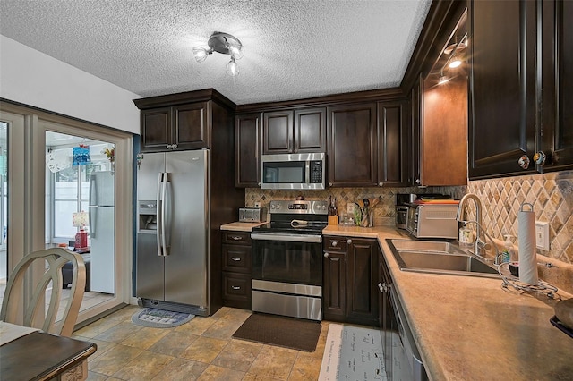 kitchen featuring sink, a textured ceiling, tasteful backsplash, dark brown cabinets, and stainless steel appliances