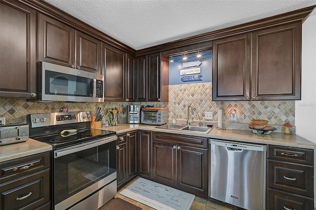 kitchen featuring backsplash, dark brown cabinetry, sink, and appliances with stainless steel finishes