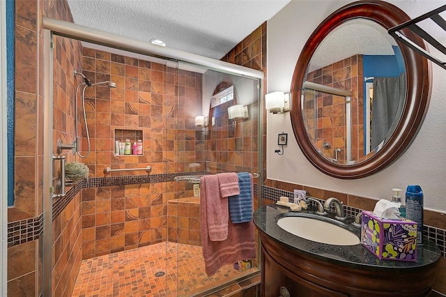 bathroom with vanity, a textured ceiling, and an enclosed shower