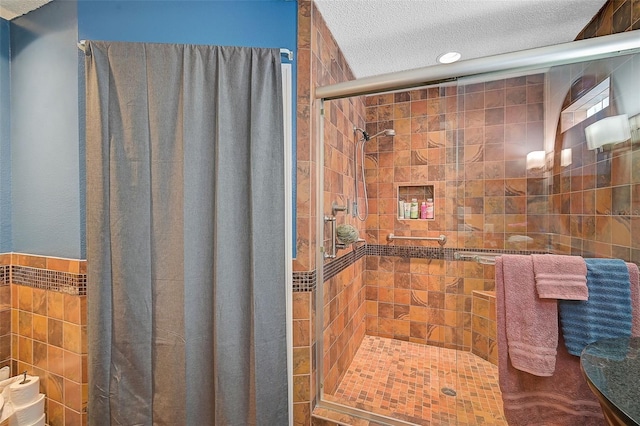 bathroom with tiled shower, a textured ceiling, and tile walls