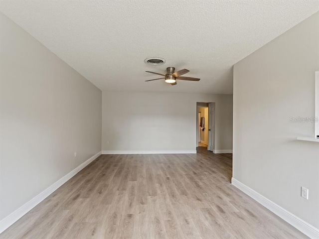 empty room featuring ceiling fan, light hardwood / wood-style flooring, and a textured ceiling