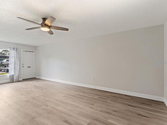 spare room with ceiling fan, a textured ceiling, and hardwood / wood-style flooring