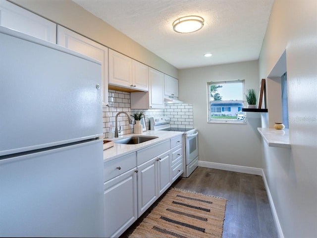 kitchen featuring white cabinets, dark wood-type flooring, backsplash, white appliances, and sink