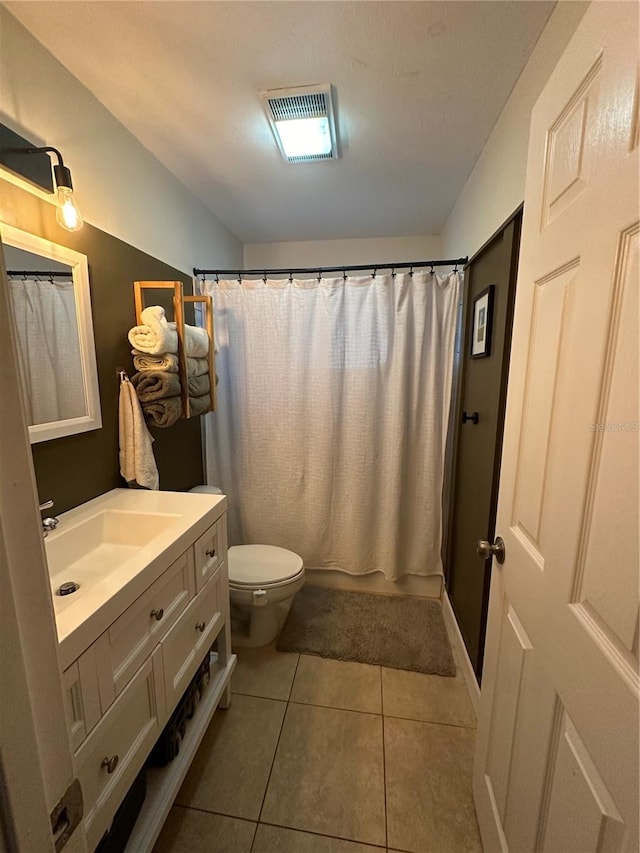 bathroom featuring toilet, vanity, and tile patterned flooring