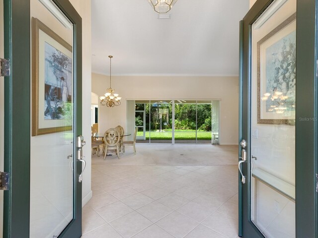 interior space featuring light tile patterned flooring, crown molding, and a notable chandelier