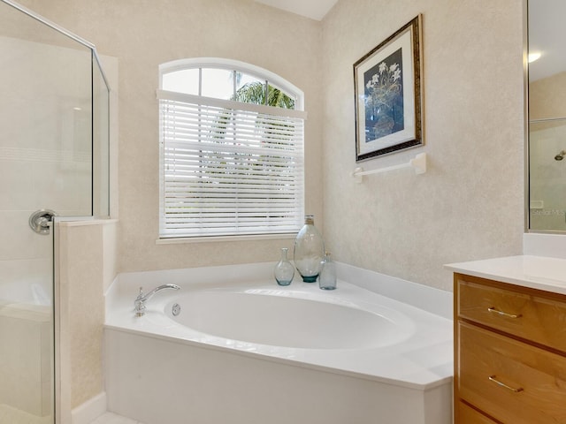 bathroom with a garden tub, a shower stall, and vanity