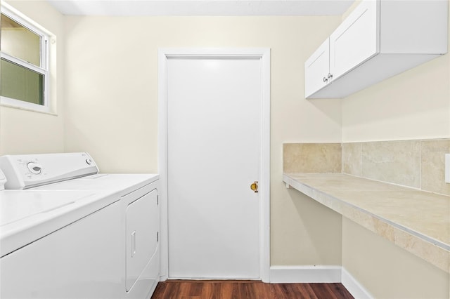 washroom featuring cabinets, dark hardwood / wood-style flooring, and washer and clothes dryer