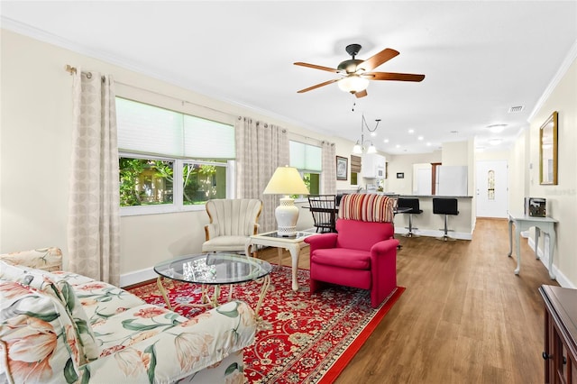 living room featuring ceiling fan, wood-type flooring, and crown molding