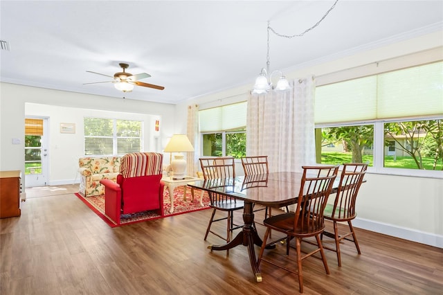 dining space featuring wood-type flooring, a wealth of natural light, and ornamental molding