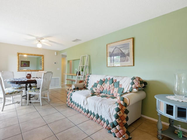 tiled living room with a textured ceiling and ceiling fan