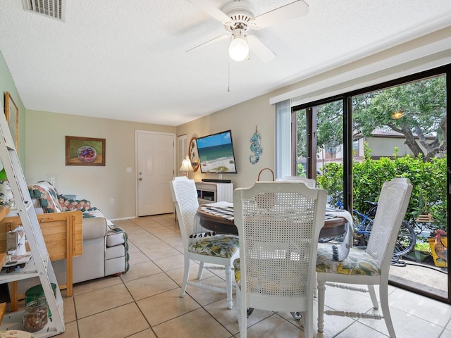 tiled dining space featuring ceiling fan and a textured ceiling