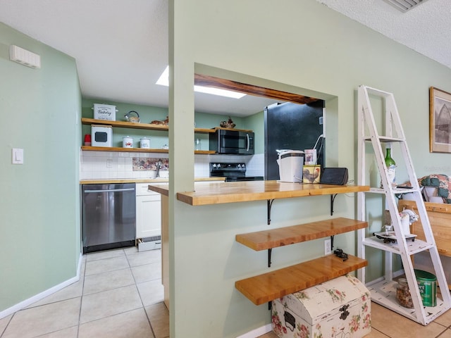 kitchen featuring stainless steel appliances, a textured ceiling, tasteful backsplash, and light tile patterned flooring