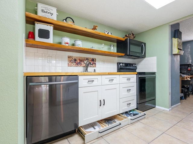 kitchen with light tile patterned floors, appliances with stainless steel finishes, sink, butcher block counters, and white cabinets