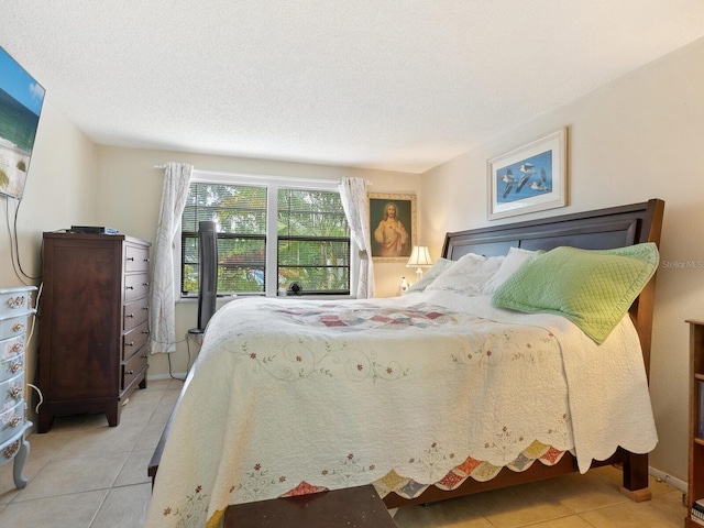 bedroom with a textured ceiling and light tile patterned floors