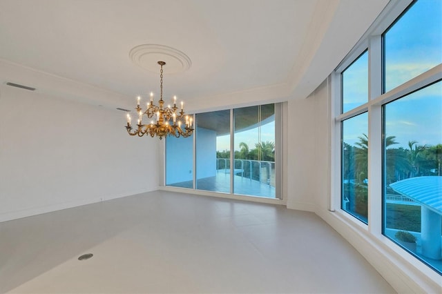 spare room with expansive windows and a notable chandelier