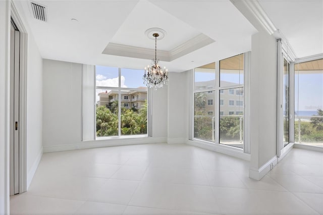 unfurnished dining area featuring a raised ceiling, light tile patterned flooring, a healthy amount of sunlight, and an inviting chandelier