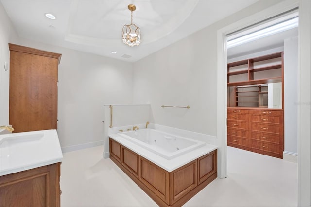 bathroom featuring a washtub, a tray ceiling, and sink