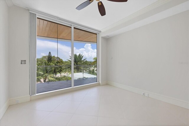 tiled spare room with floor to ceiling windows, a wealth of natural light, and ceiling fan