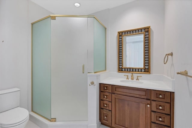 bathroom with vanity, toilet, and a shower with door