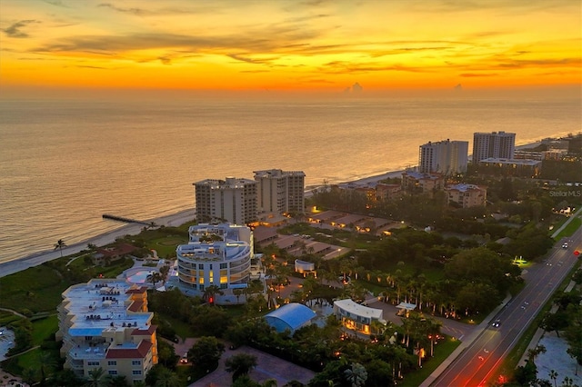 aerial view at dusk featuring a water view