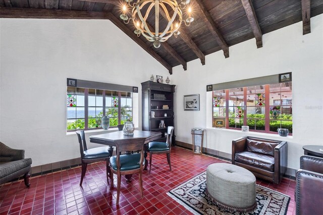 tiled dining area featuring beamed ceiling, high vaulted ceiling, wooden ceiling, and an inviting chandelier