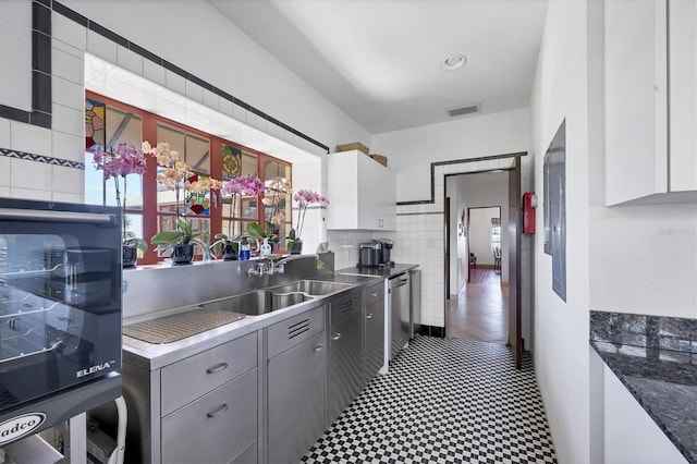 kitchen featuring white cabinets, dishwasher, gray cabinets, and sink