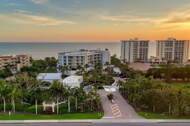 aerial view at dusk featuring a water view